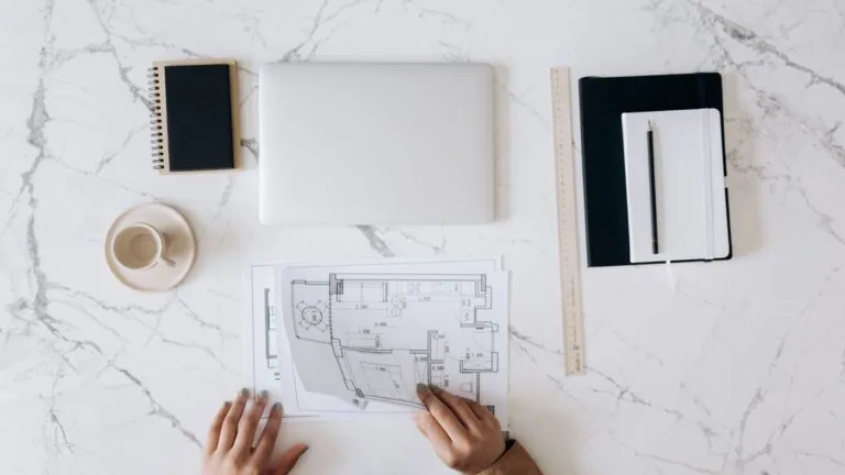 Planning a maintenance checklist at a desk with a laptop and notebook