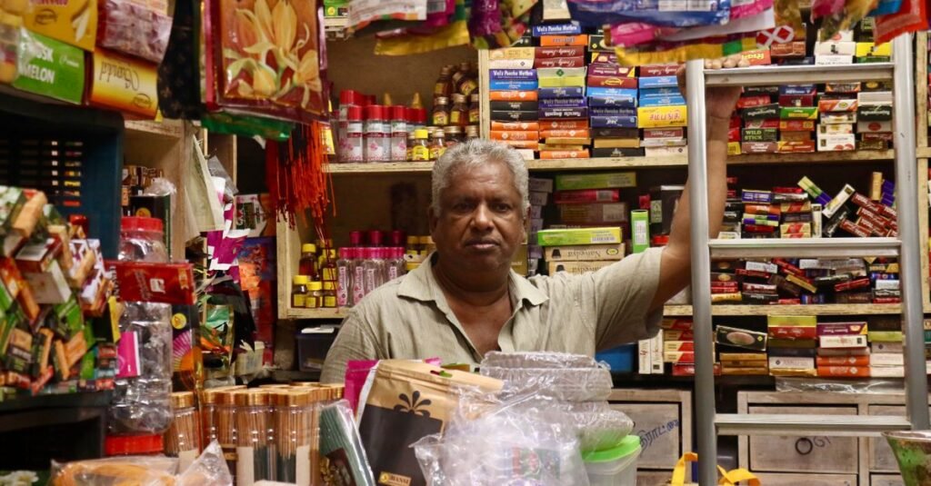 Indian small business owner standing inside a local shop
